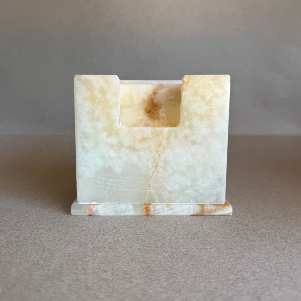 SAÉA onyx coaster holder in golden clay and burnt caramel, shown empty from the front with warm honey veining.