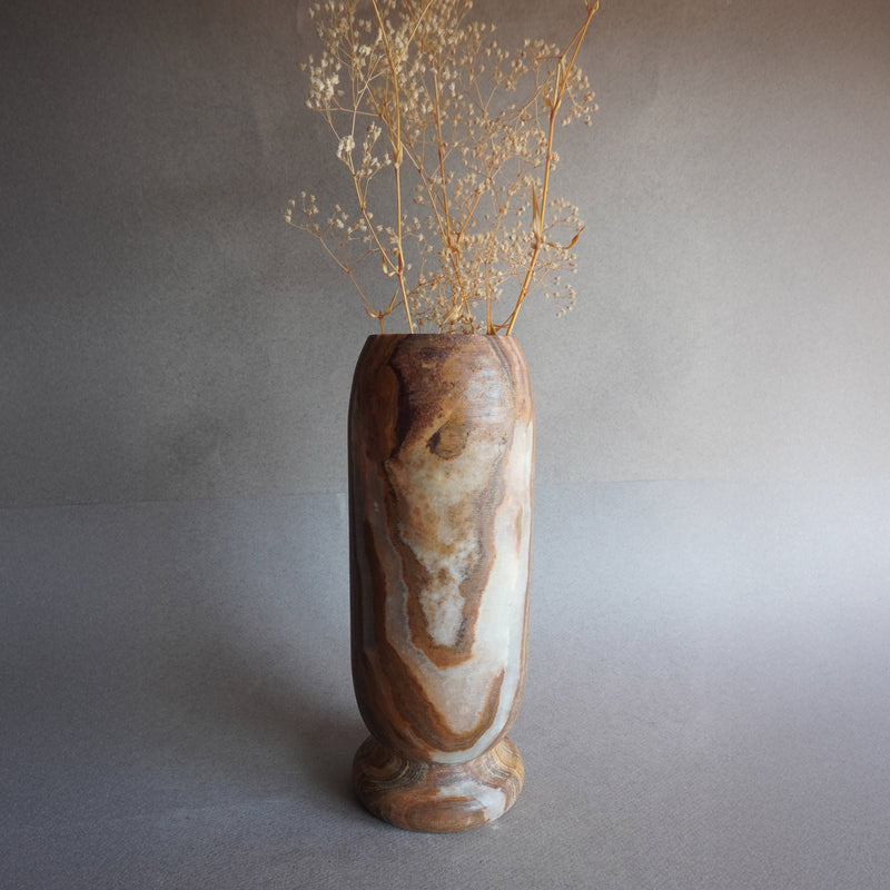 Hand-carved tall onyx vase in earth brown, ivory, and golden rust tones, sculptural stone vessel for flowers or home decor