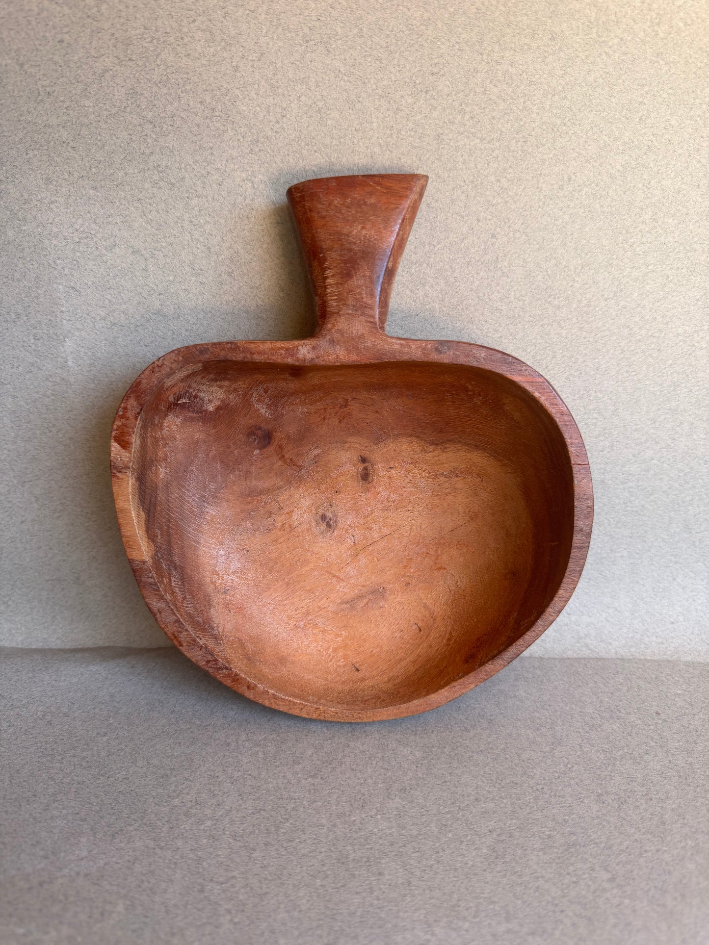 Wooden bowl with a handle on a beige background