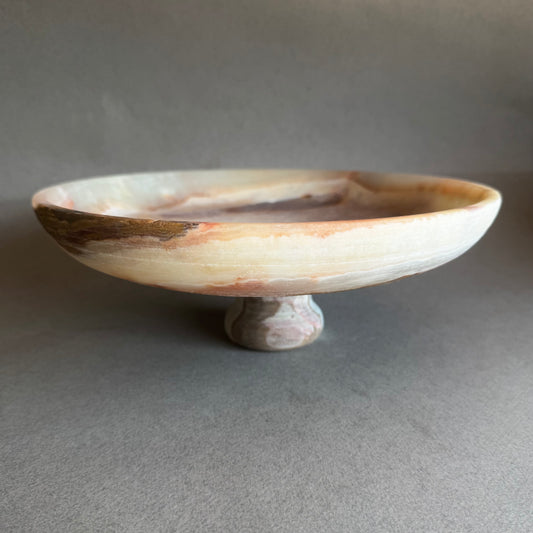 pink onyx  Decorative bowl on a stand with a speckled design against a neutral background