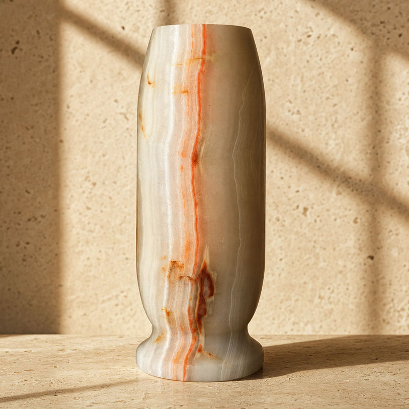 Close-up of the footed base of an ivory onyx Origin Vase, showing the rust vein reaching the pedestal foot.