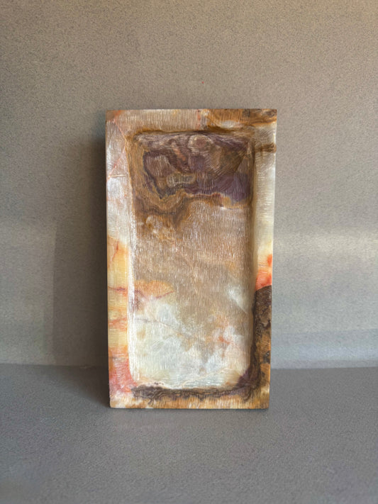 Rectangular stone with marbled pattern on a gray background