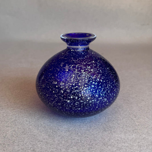 Blue speckled vase on a gray background