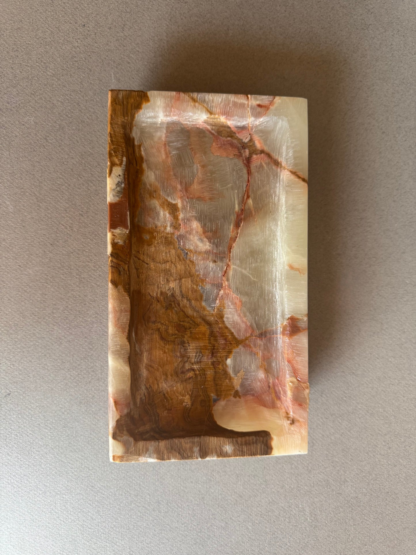 Rectangular stone with marbled pattern on a gray background