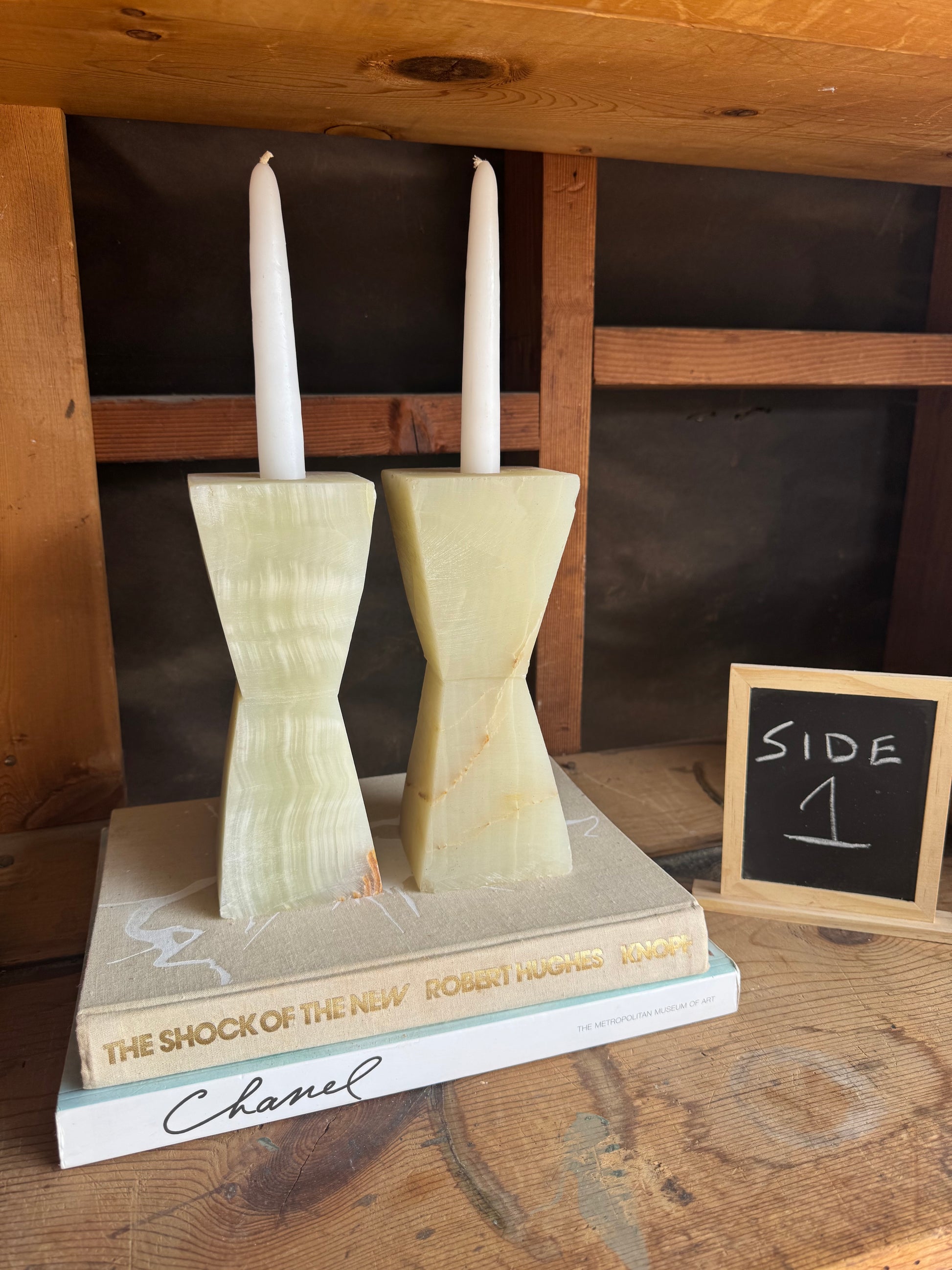 Close-up of handcrafted onyx candle holders with curved hourglass design