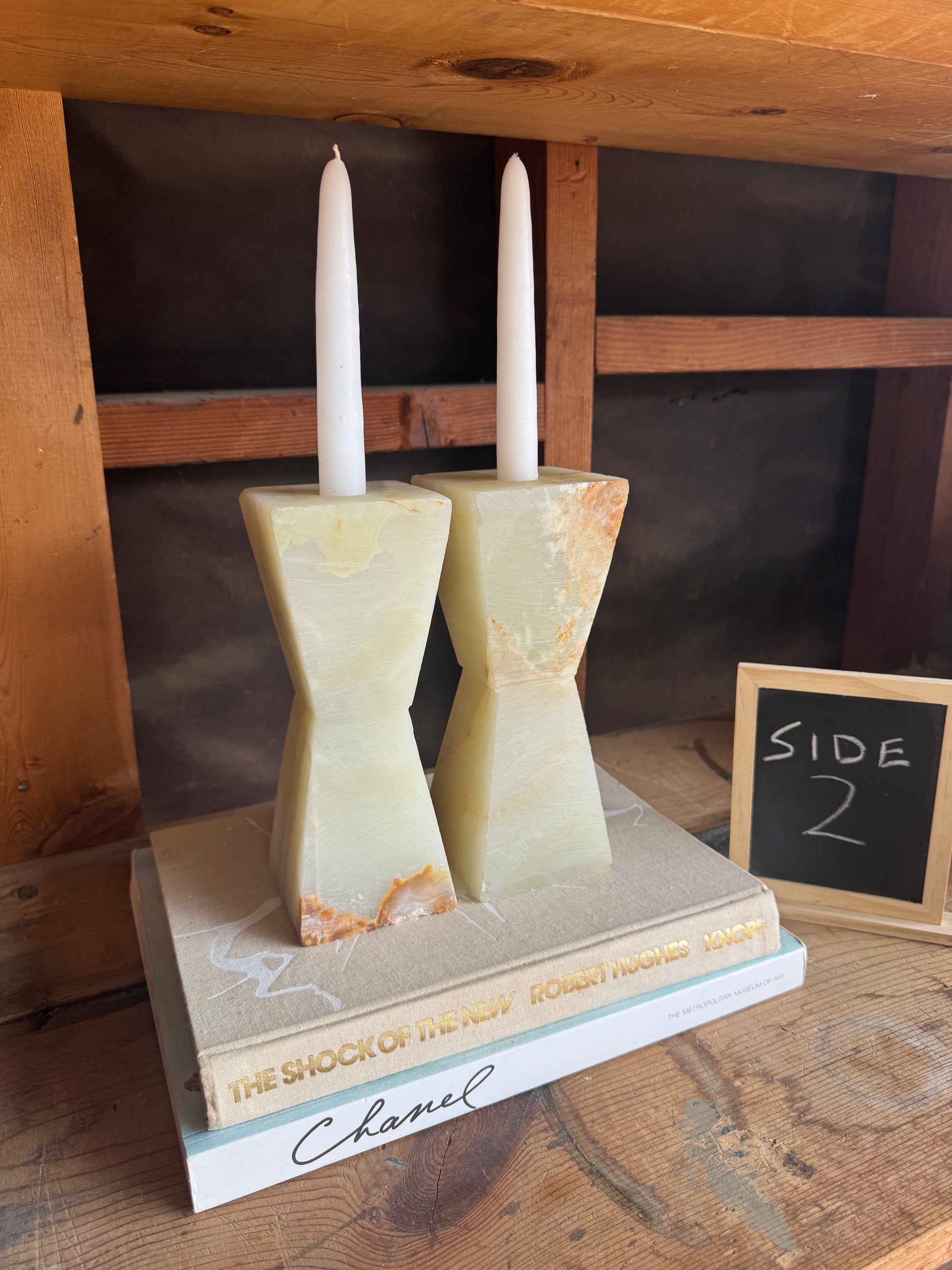 Cream and nude green taper holders styled on tabletop with candles inserted