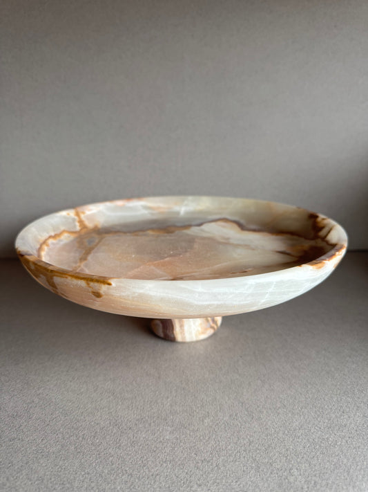 Top view of sculptural onyx bowl with pale green and gray marbling, highlighting organic stone patterns