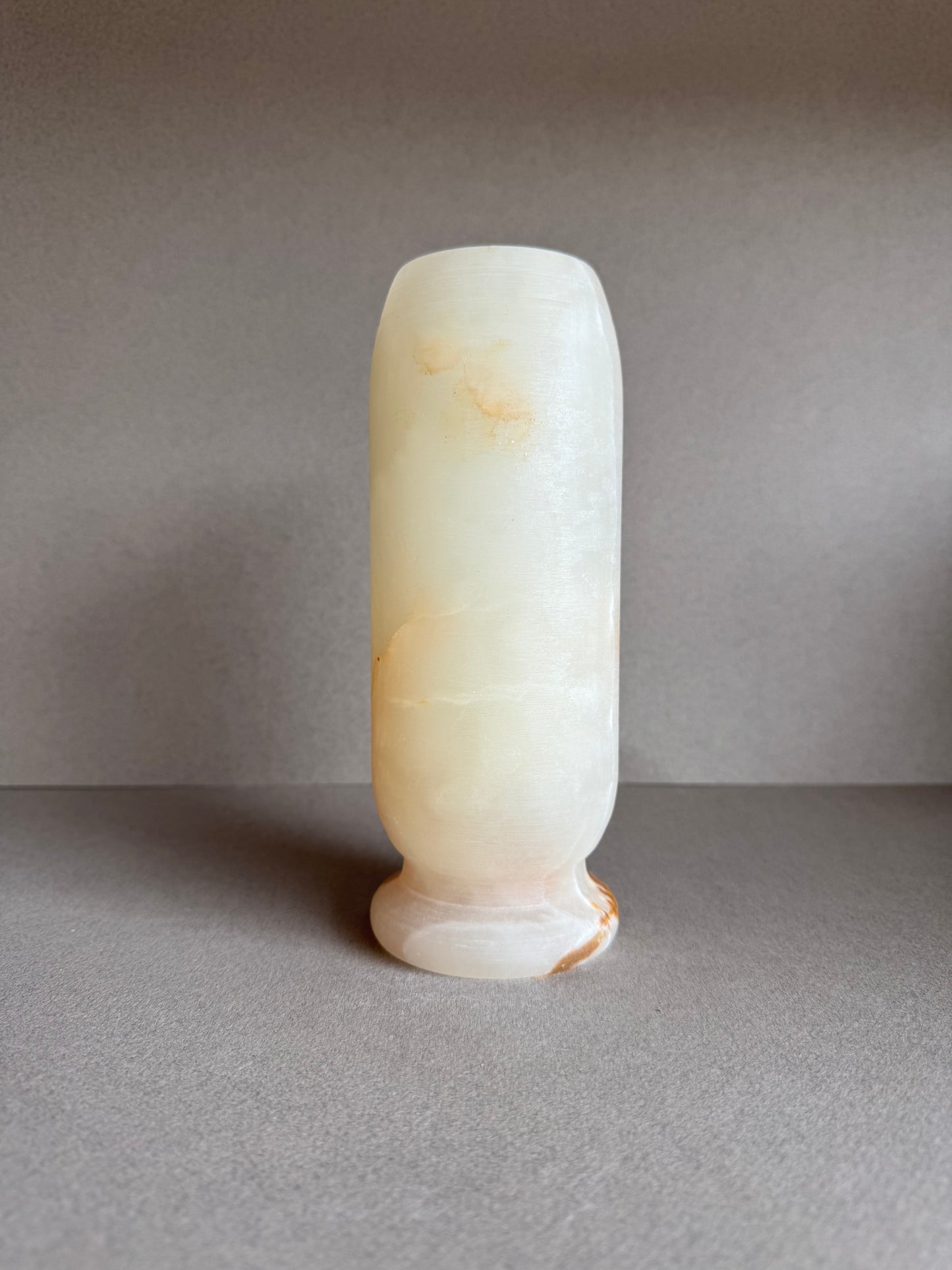Back view of onyx vase showing gradient tones from peach to sand.