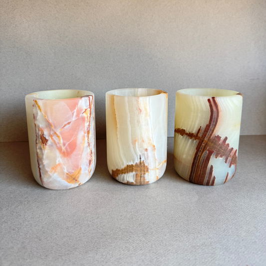 Three marbled stone cups on a neutral background