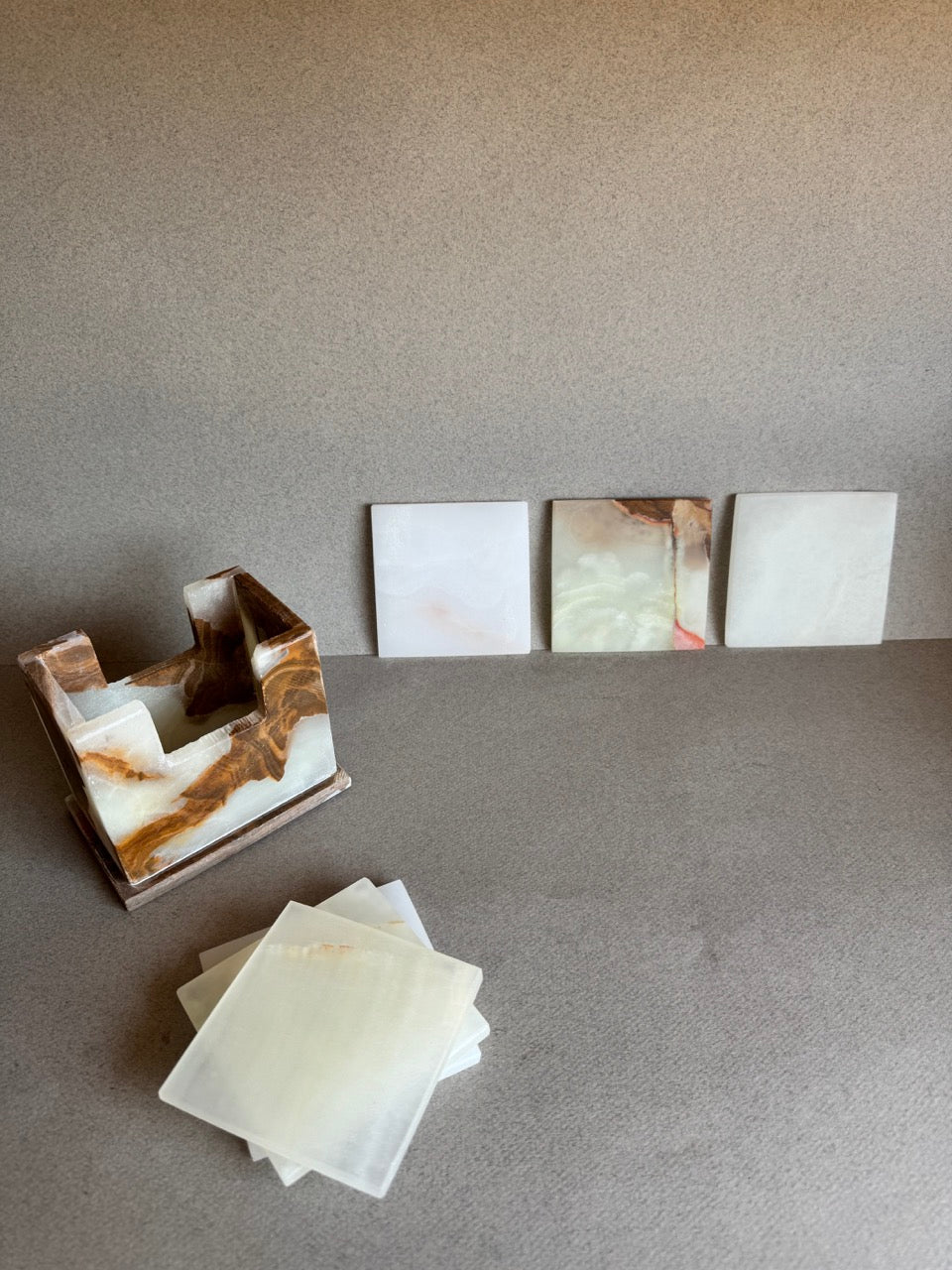 SAÉA onyx coaster set displayed with coasters partially removed from matching carved stone holder