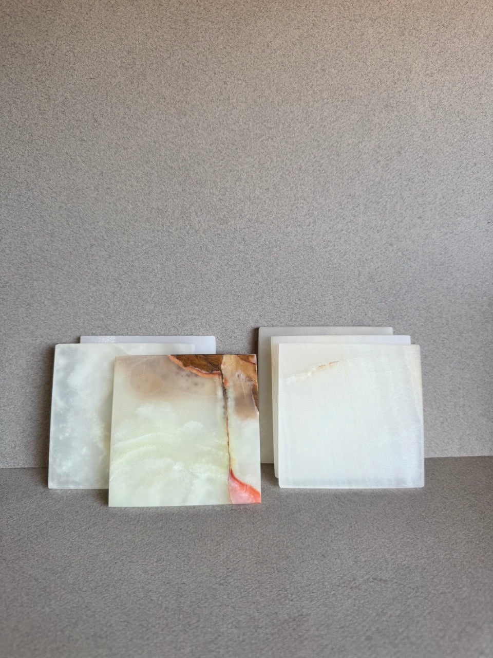 Side-by-side display of two stacked SAÉA onyx coaster sets showing veining variation and translucent finish
