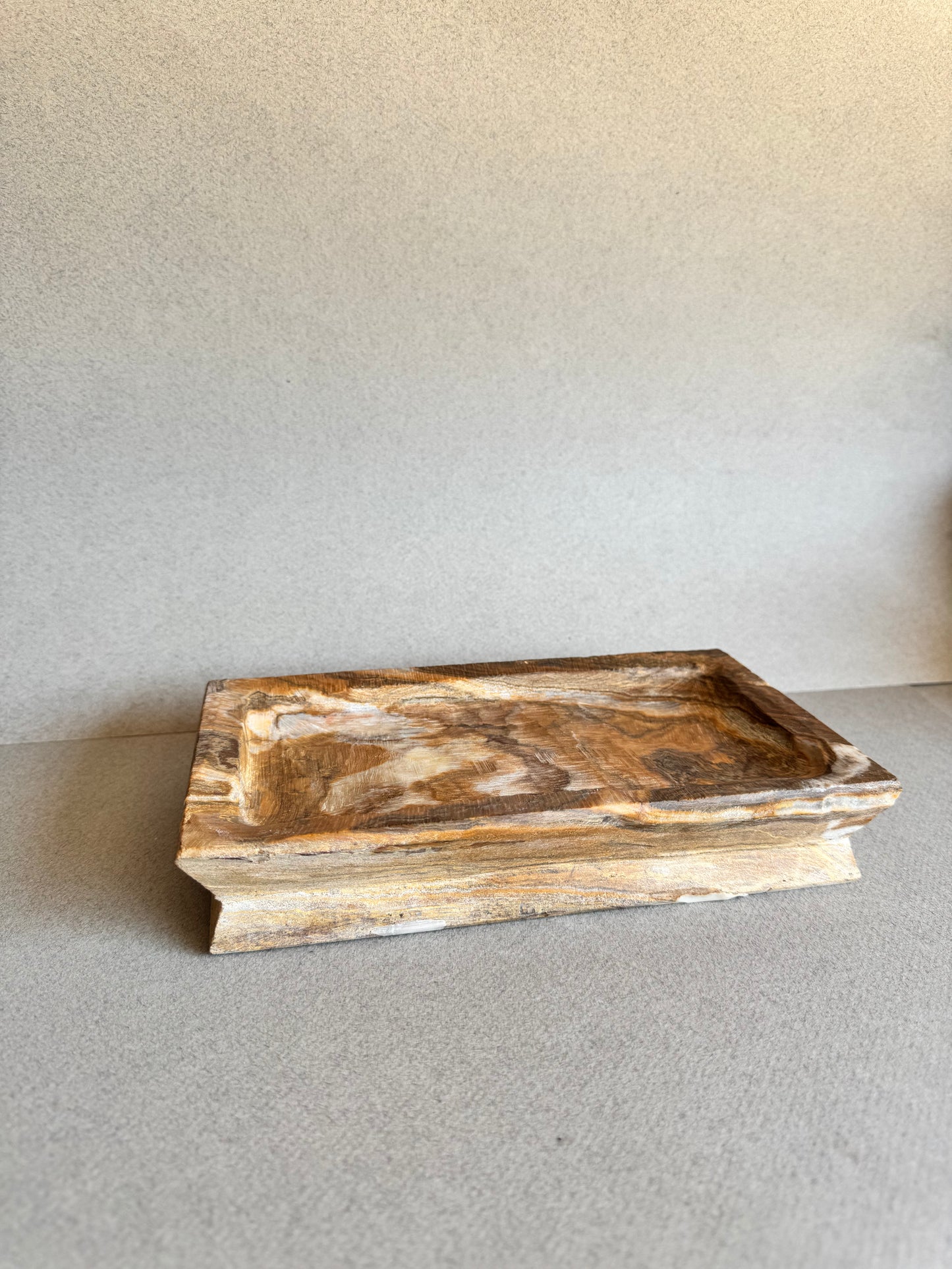Side angle of SAÉA rectangular natural stone tray with marbled amber veining