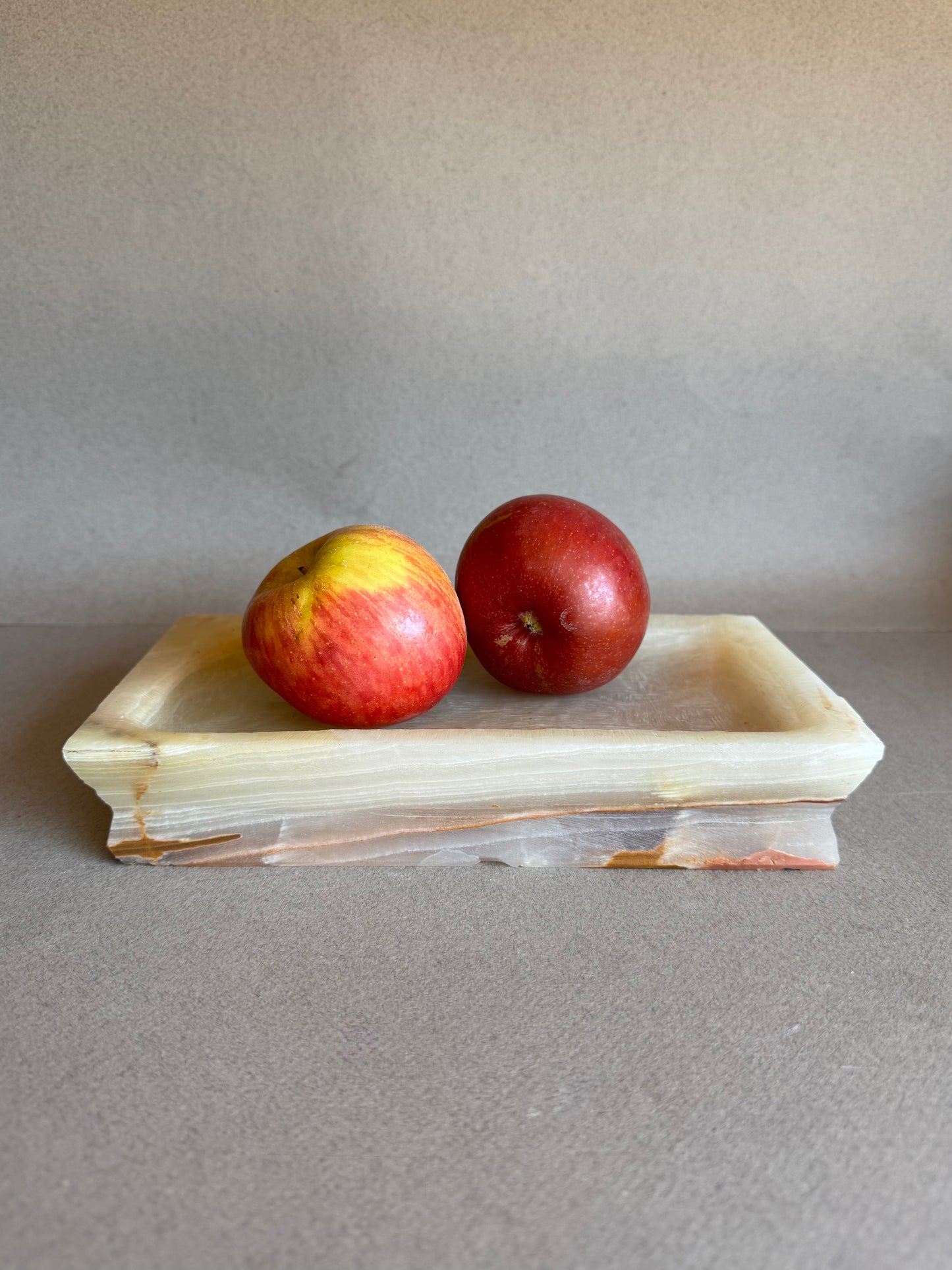 Blush and honey-toned onyx tray used as a fruit bowl on tabletop