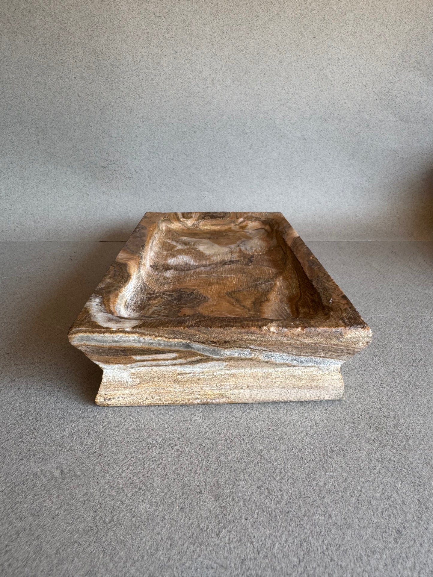 Side angle of rectangular natural stone tray with marbled amber veining