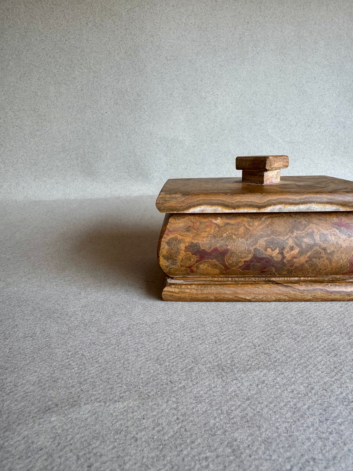 Golden onyx box used for storing rings and earrings, styled as a jewelry container