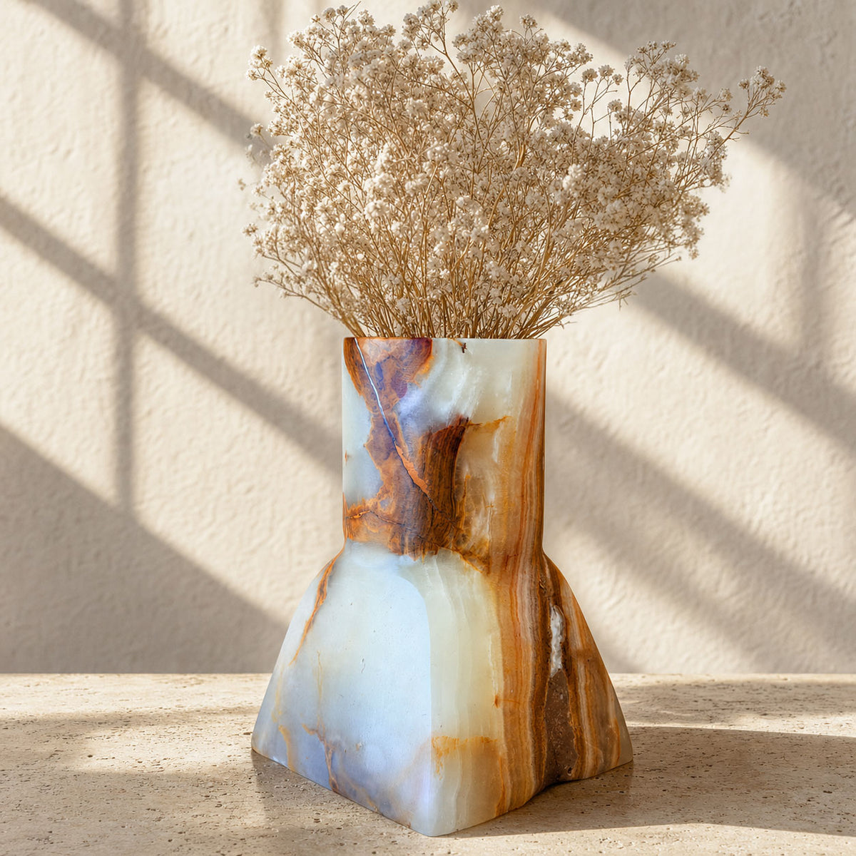 Onyx Dune Vase in slate and amber styled with dried baby's breath, showing a fine natural line near the rim.
