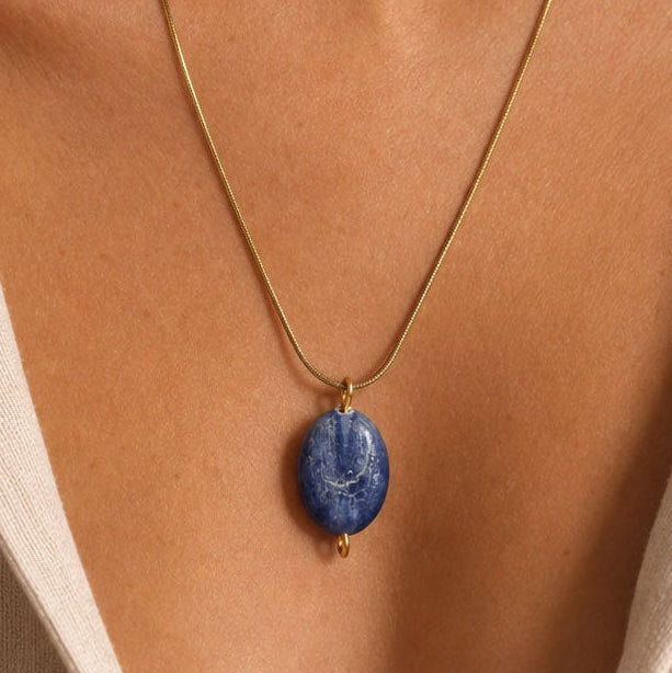 Necklace with a blue kyanite pendant on a person's neck