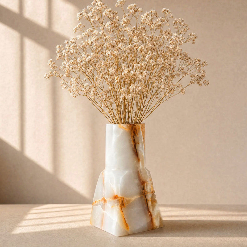 Decorative white pink onyx vase with dried flowers on a neutral background