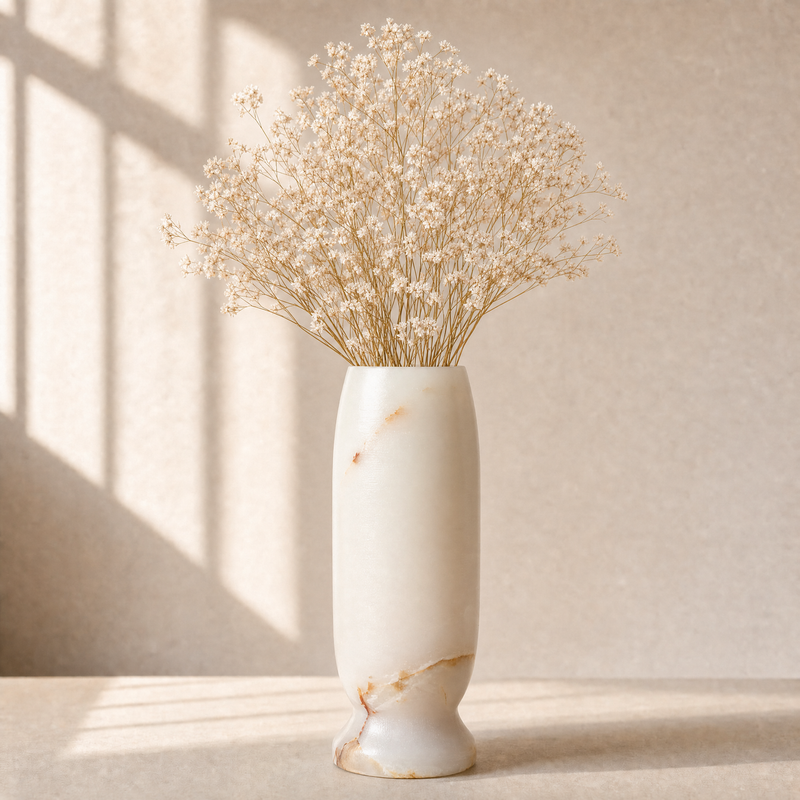 White marble vase with dried flowers on a light background