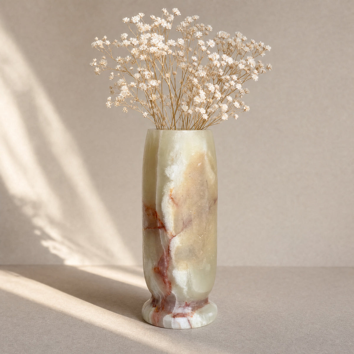 Marble-patterned vase with dried flowers on a neutral background