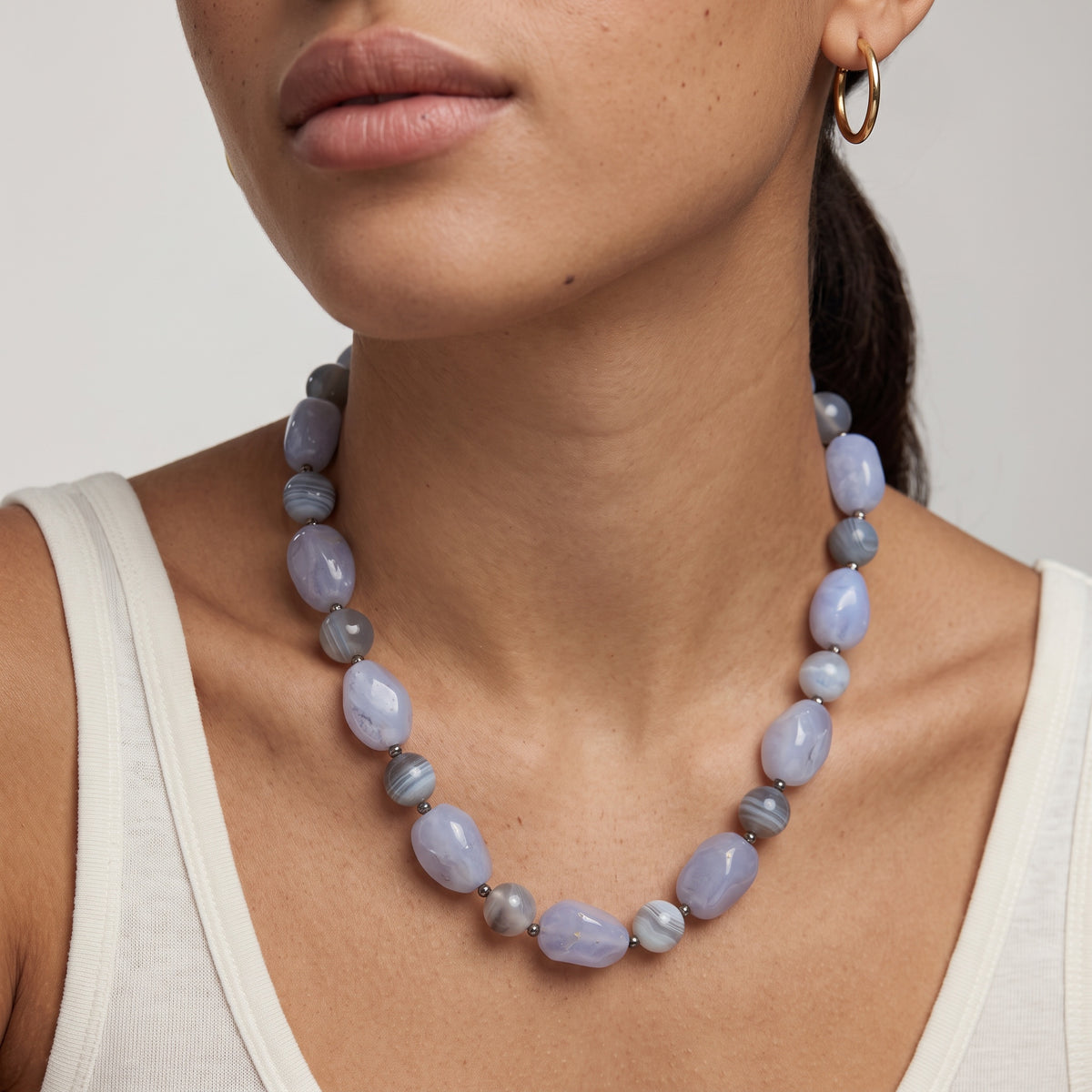 Blue lace agate beaded necklace worn on a model in a white tank top