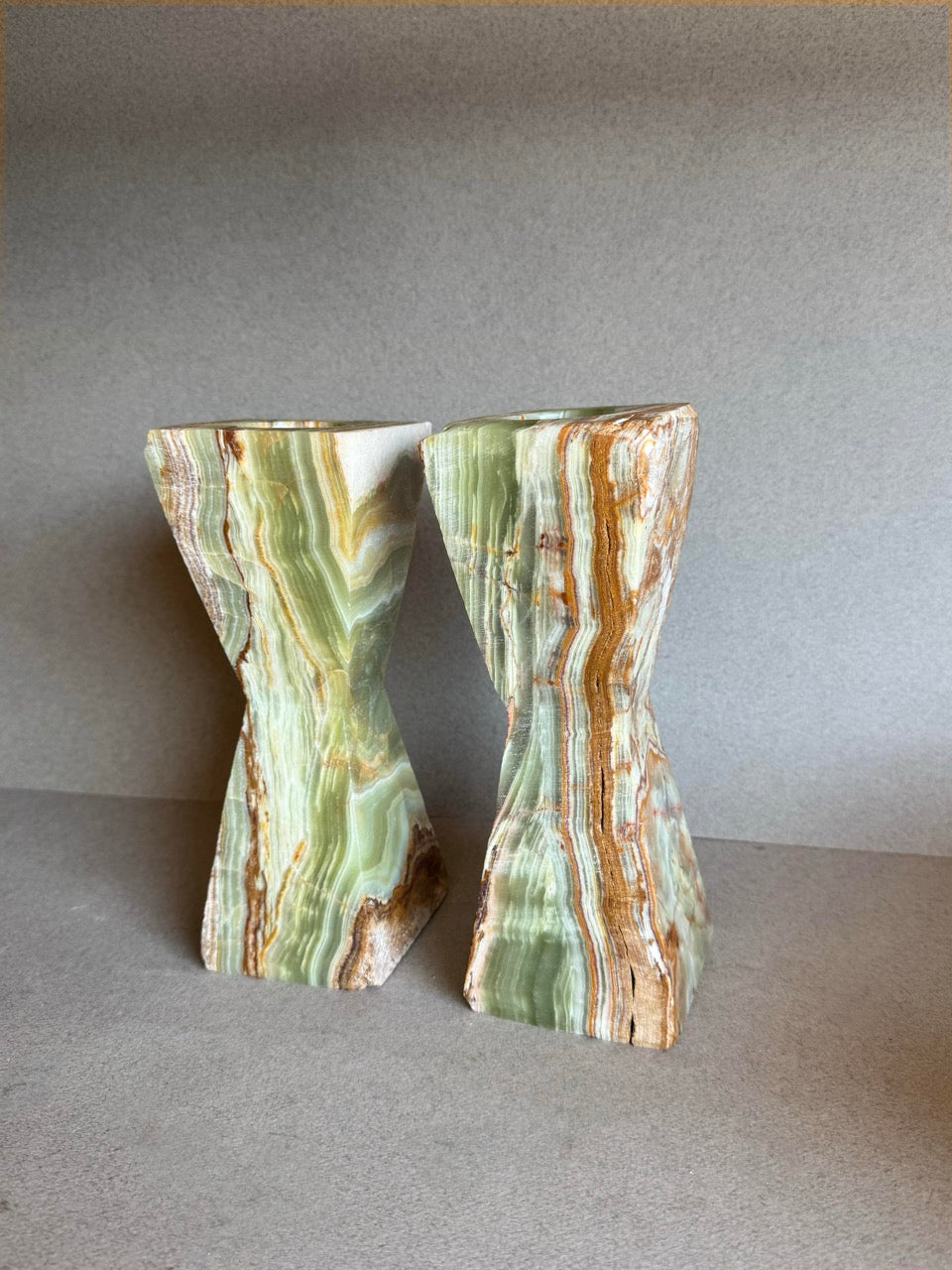 Sustainable onyx candle holders glowing with layered earth-toned striations