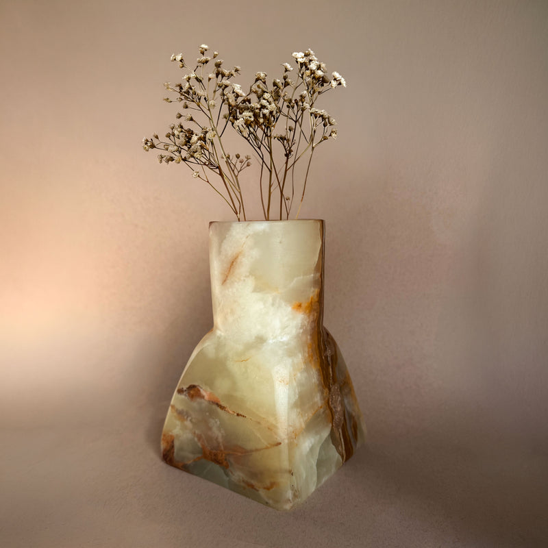 Marble-patterned onyx vase with dried flowers on a beige background