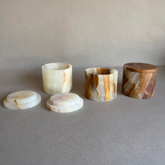 Petite hand-carved onyx keepsake jar with lid in cream, honey, and rust tones, photographed on a neutral background