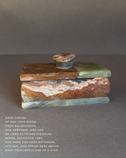 Stack of hand-carved onyx stone jars on a gray background with descriptive text.