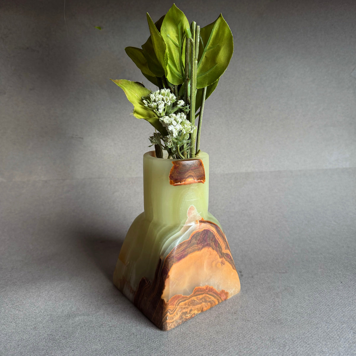 Natural onyx vase with stepped geometric silhouette in olive green and caramel tones, artisan stone vessel