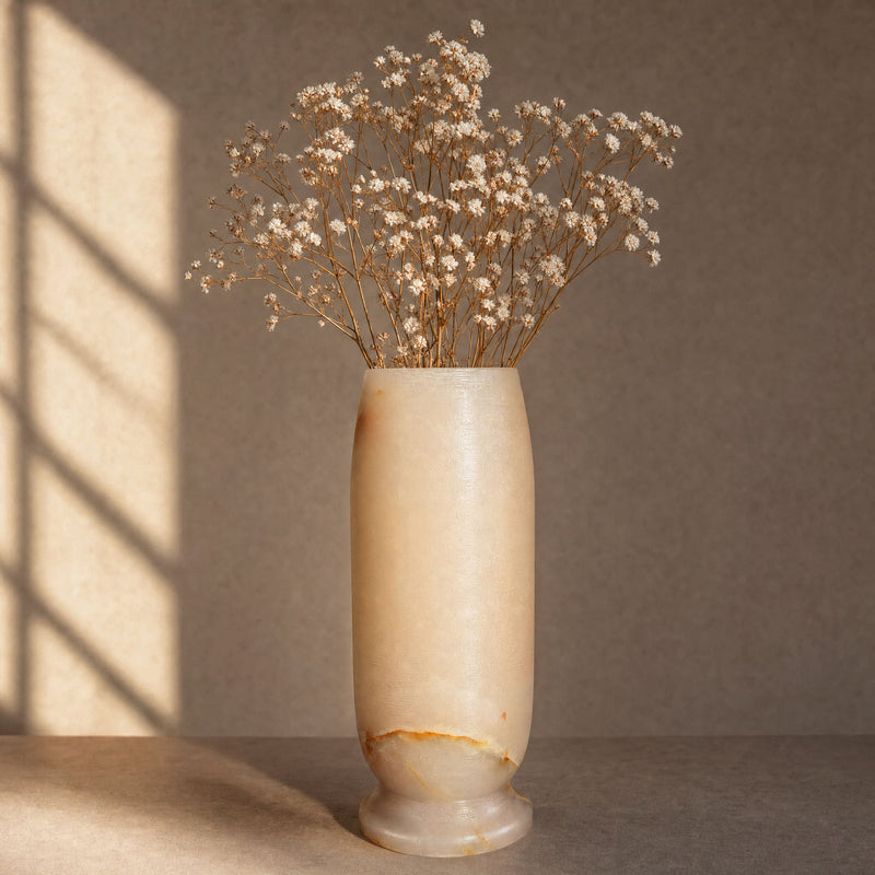 white onyx vase with dried flowers on a neutral background