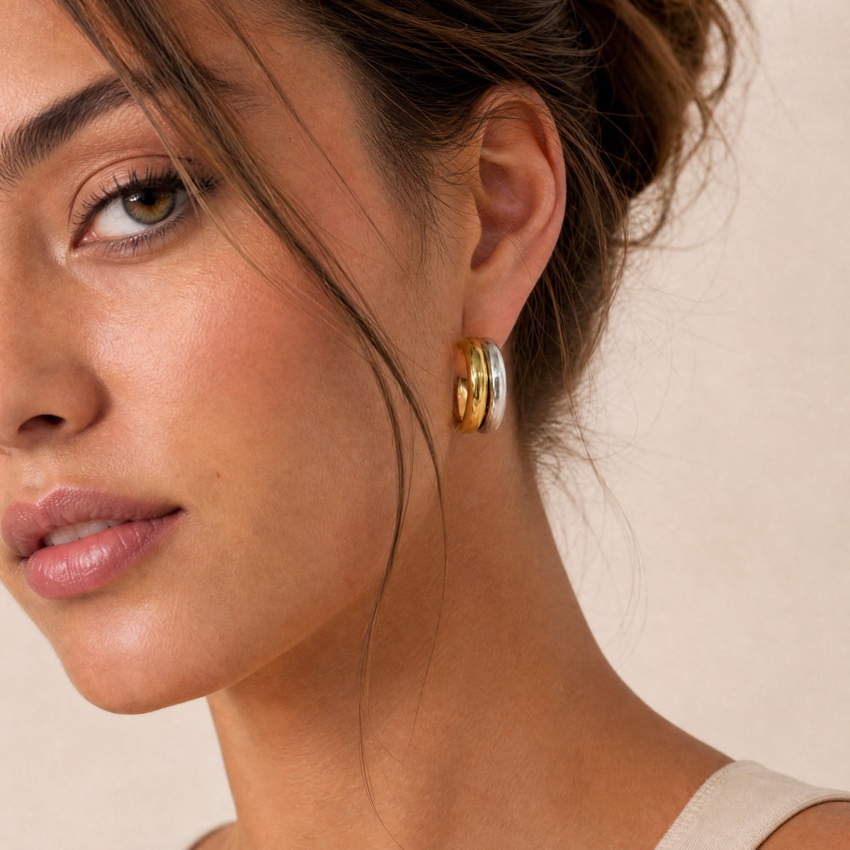 Close profile of mixed-metal double hoop earring showing chunky gold and silver bands side by side