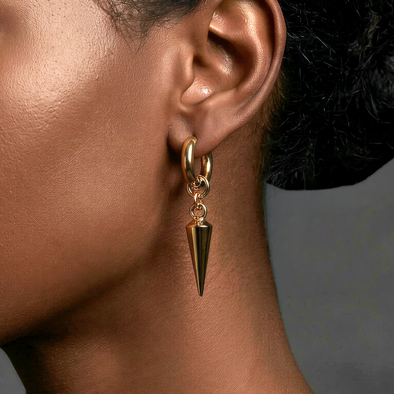 edgy Gold earring with a spike detail on an ear against a neutral background