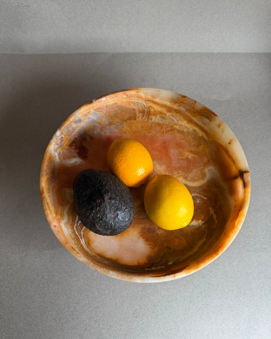 Onyx pedestal bowl used as vanity tray holding perfume and jewelry