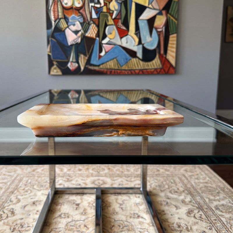 Glass coffee table with a onyx catchall tray with pink purple and gray swirls