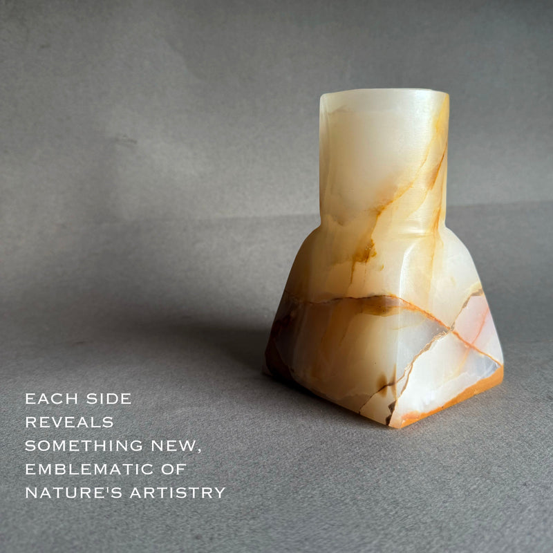 Marble-patterned pink white yellow onyx vase on a gray background with text about nature's artistry.