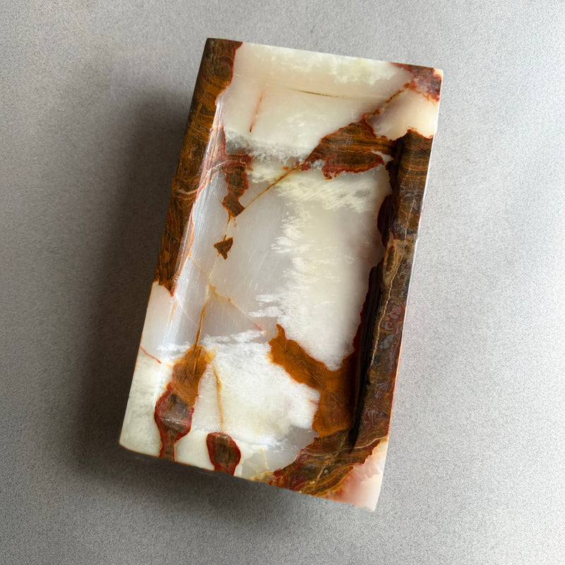 Rectangular stone onyx tray with brown and white marbled pattern on a gray background
