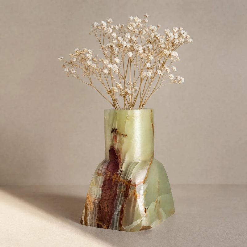 Sculptural Onyx Vase with a natural stone pattern containing dried flowers on a beige background