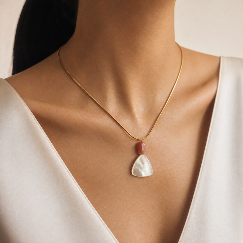 SAÉA Necklace with a mother of pearl and sunstone pendant worn by a model against a neutral background