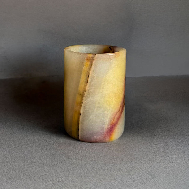 Multicolored stone cup on a gray background