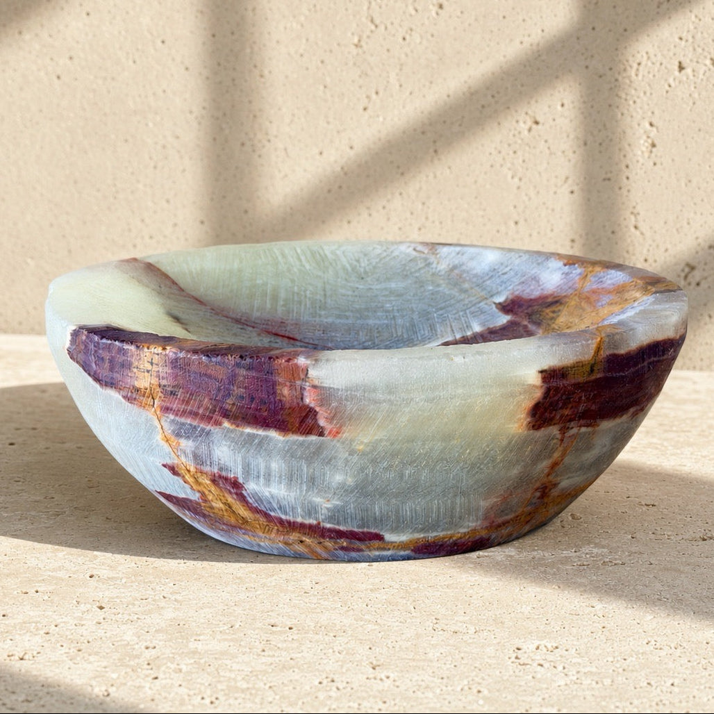 top-down view of a hand-carved onyx bowl in sage, cream, and burgundy, showing the crosshatch carving and rust veining inside the bowl.