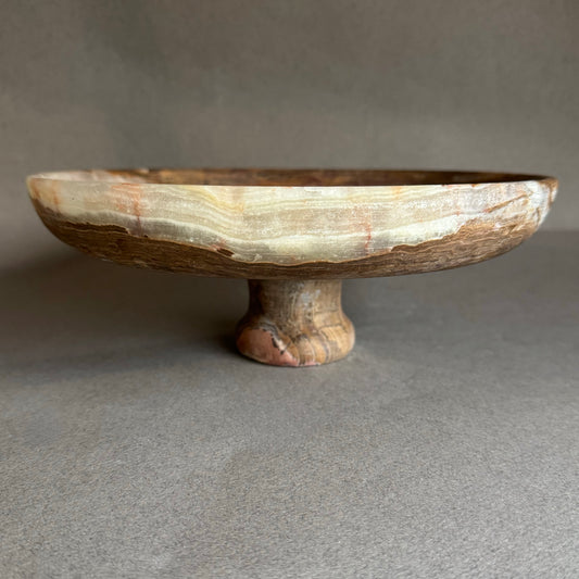 Decorative stone pedestal bowl on a gray background