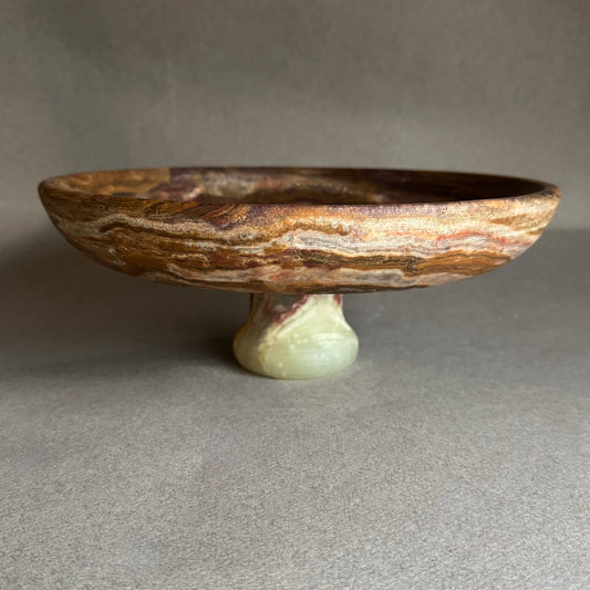 Decorative stone dish with a small pedestal on a gray background