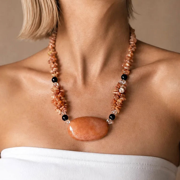 Model wearing a chunky beaded gemstone collar necklace with a large polished carnelian centerpiece, handmade by SAÉA in San Diego.