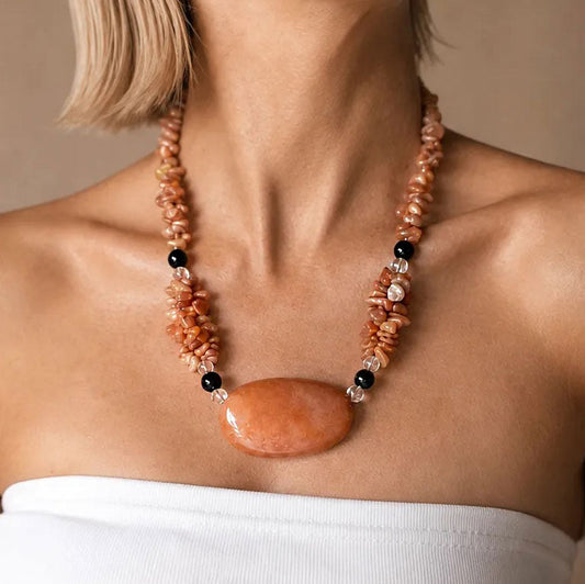 Model wearing a chunky beaded gemstone collar necklace with a large polished carnelian centerpiece, handmade by SAÉA in San Diego.