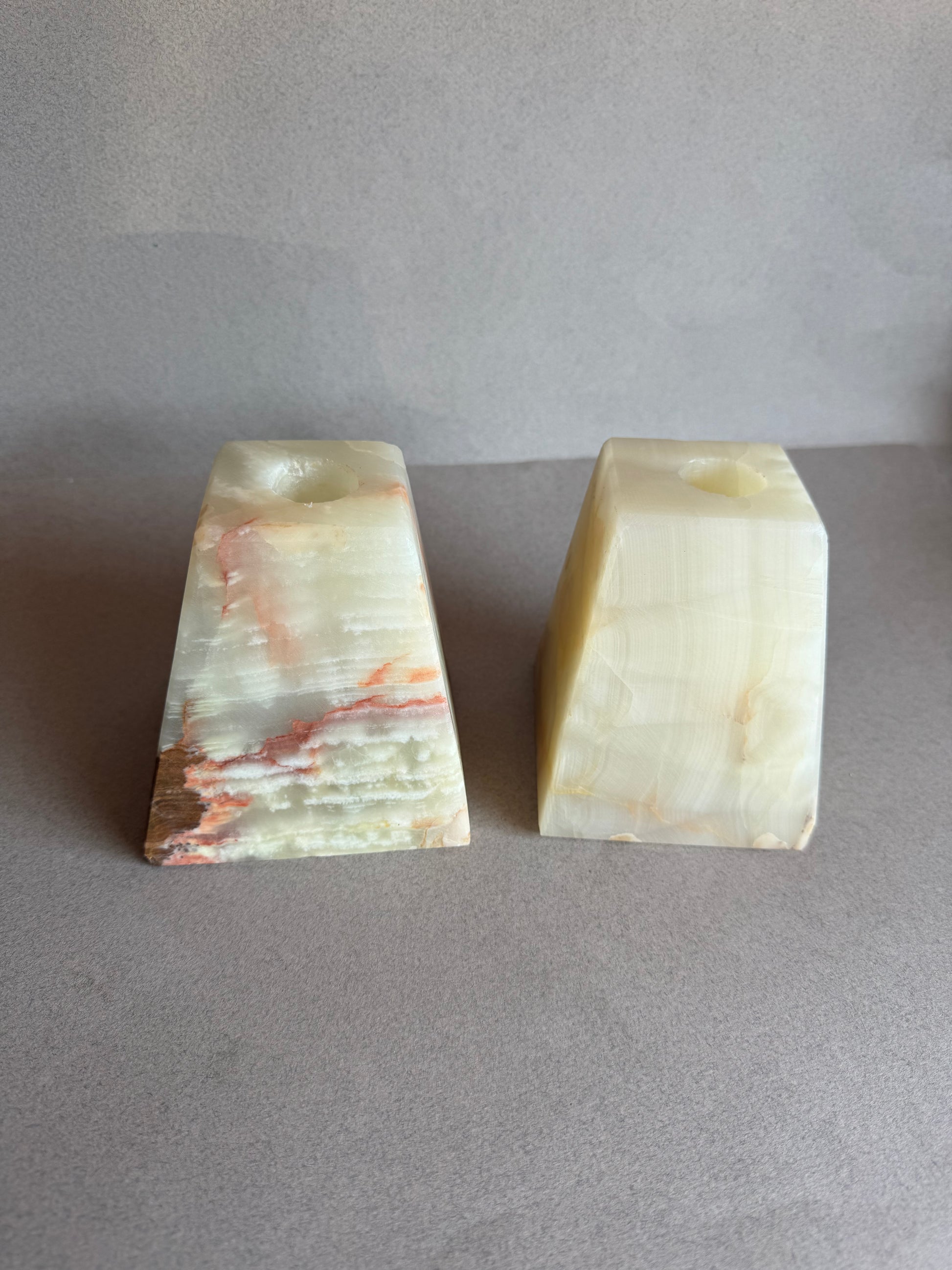 Hand-carved natural stone taper holders with amber, rust, and cream veining

