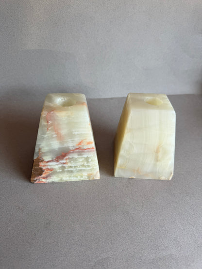 Hand-carved natural stone taper holders with amber, rust, and cream veining


