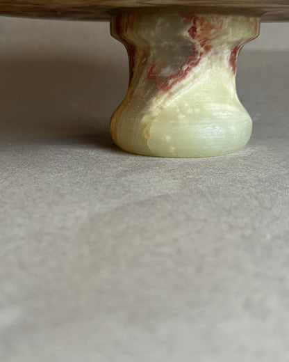 Close-up of a marble-like pedestal base on a neutral background