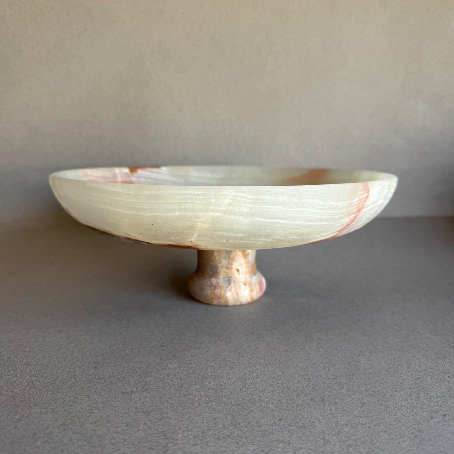 Front view of large onyx centerpiece bowl with pedestal base and soft natural tones