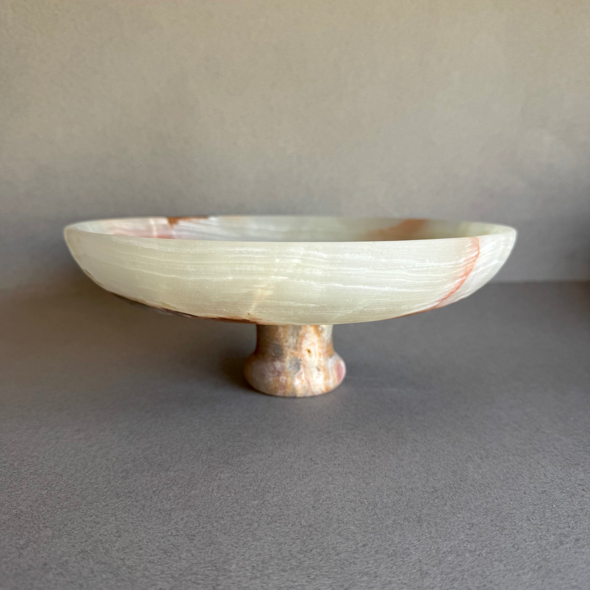 Front view of large onyx centerpiece bowl with pedestal base and soft natural tones